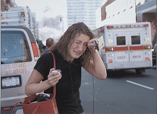 A woman reacts on a New York City street with ambulances behind her following the September 11 attacks